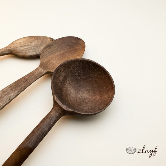 Zlayf set of three rustic wooden spoons in varying shades of brown, showcasing natural wood grain. Ideal for stirring and serving.